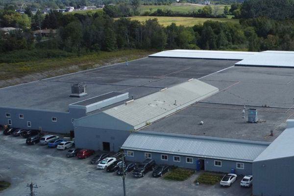 High-angle aerial view of the large North American Steel manufacturing facility and parking lot in Colborne, Ontario.