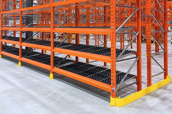 Multi-tier orange carton flow warehouse racking solution featuring integrated roller beds and bright yellow post guards for order fulfillment.