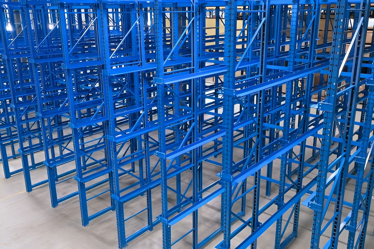 High-angle view looking down into empty blue drive in pallet racking lanes in a high-density warehouse environment.