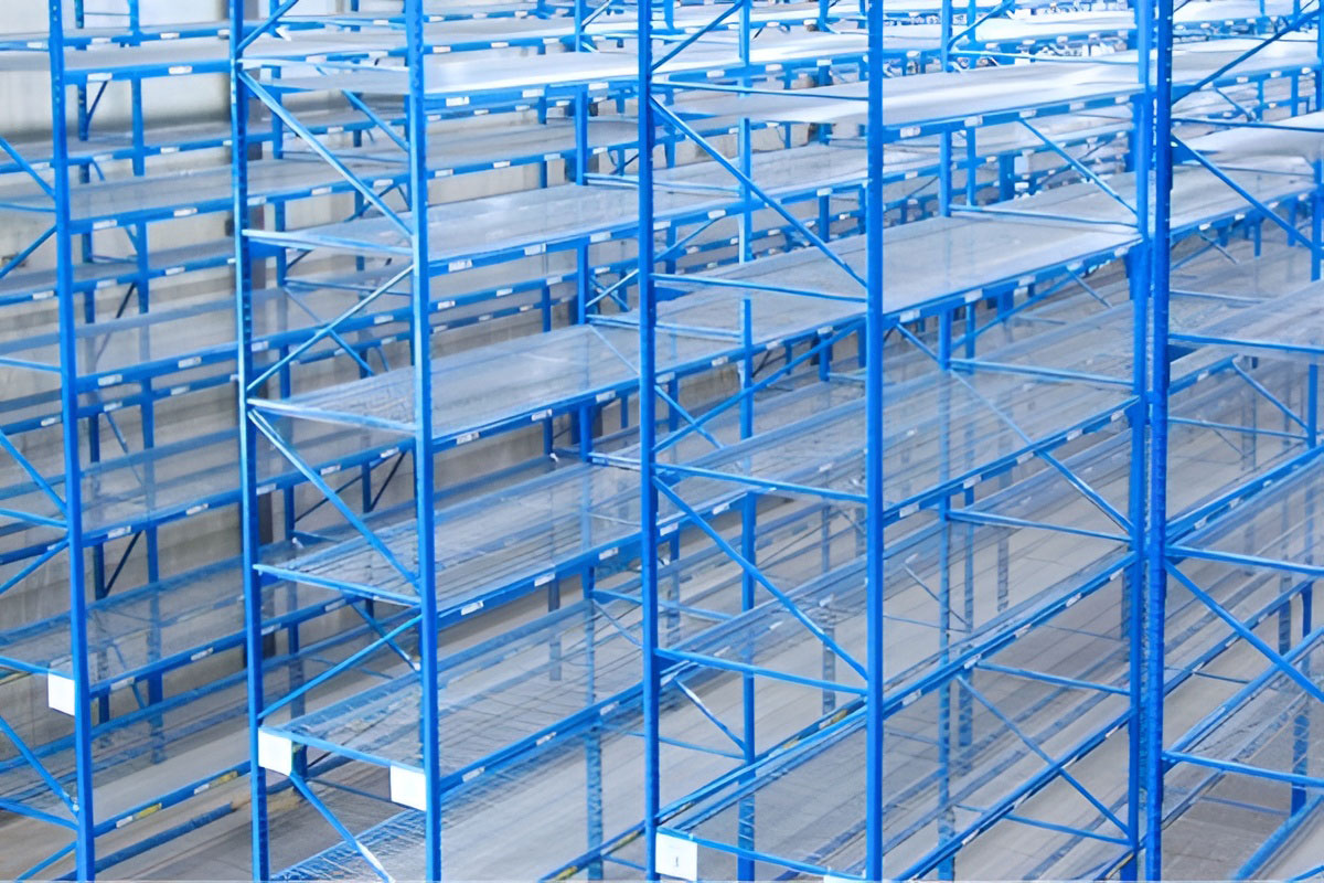 Elevated view of empty blue selective pallet racks with wire mesh decking installed across multiple storage levels.