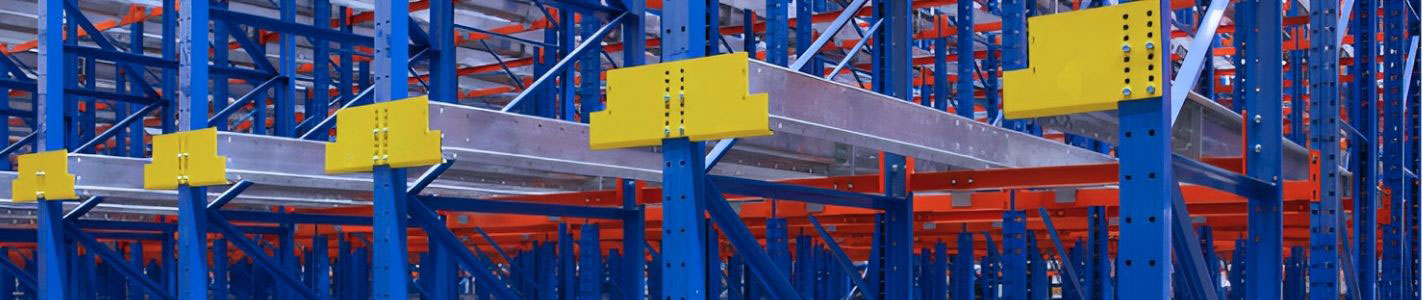 Detailed close-up view of a high-density shuttle cart pallet racking system, featuring galvanized guide rails with yellow entry funnels mounted to blue steel uprights and orange cross-beams.